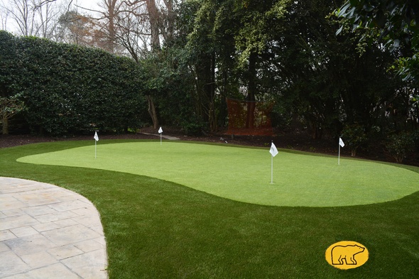 Charlotte Synthetic grass golf green with 4 holes and flags in a landscaped backyard