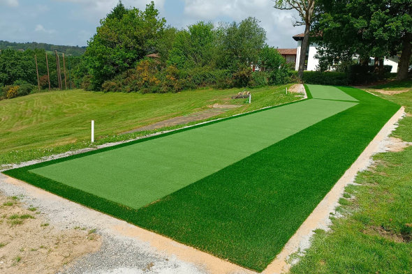 Charlotte Outdoor tee line consisting of one continuous green synthetic grass strip surrounded by trees