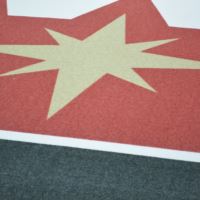 A close up image of artificial turf with a star design printed on it.