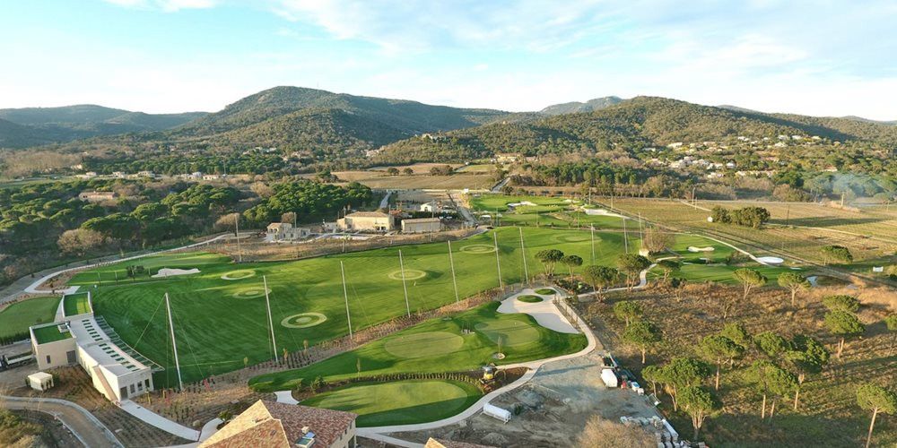 Charlotte Aerial view of a synthetic grass golf course surrounded by hills